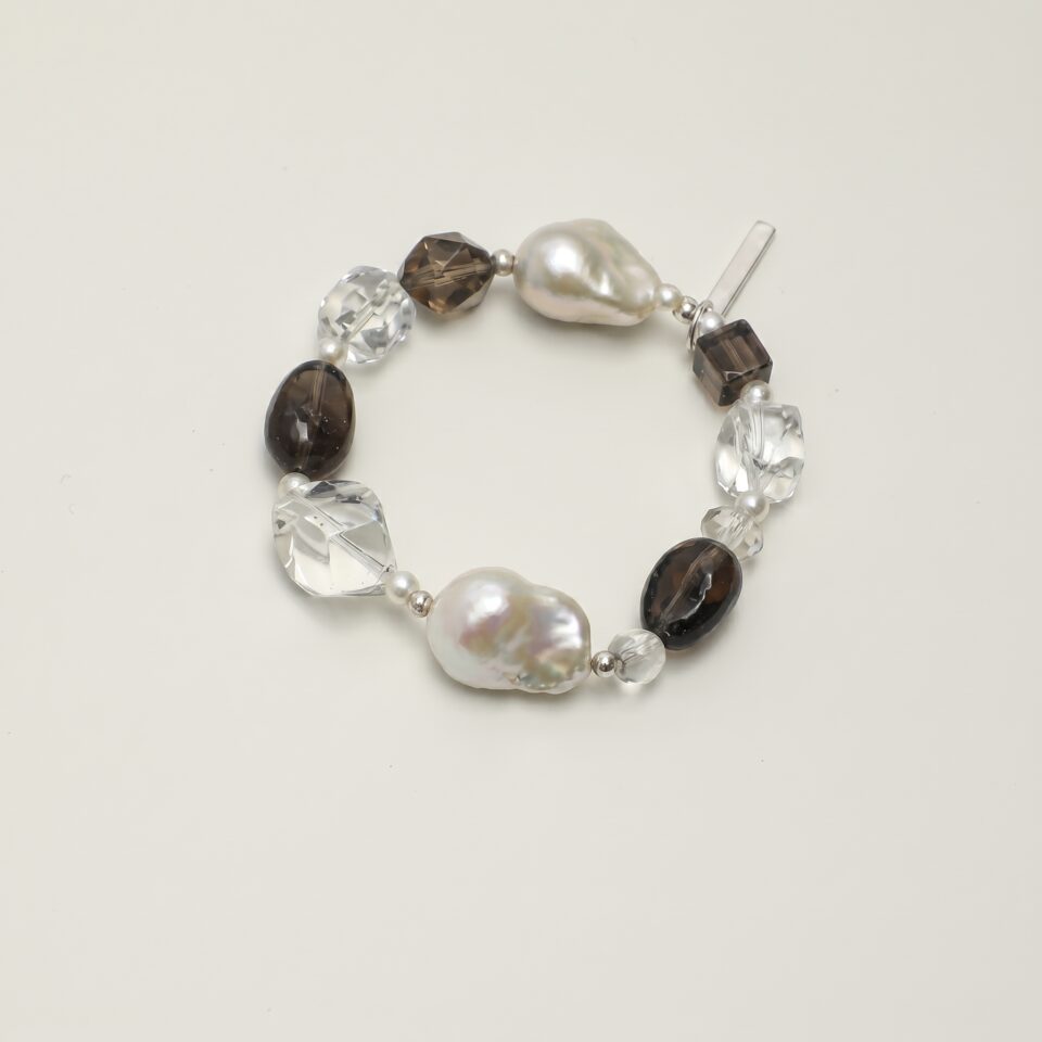 Clear Quartz, Smoky Quartz & Cultured Pearl Bracelet photographed on a pale background