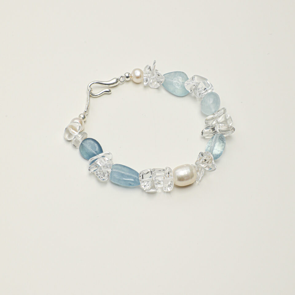 Clear Quartz, Aquamarine & Cultured Pearl Bracelet photographed on a pale background